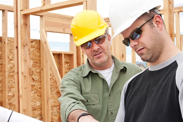 Construction managers review plans for a new home in progress.