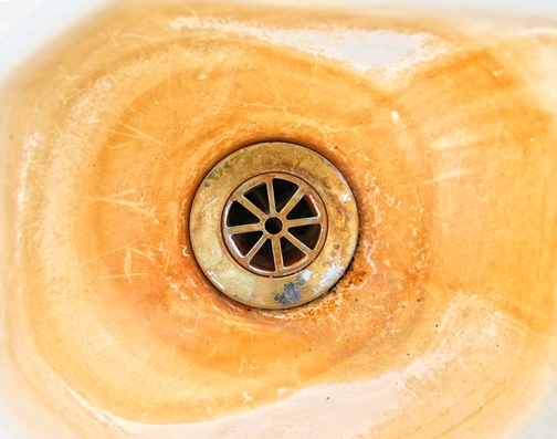 An example of unsightly mineral build-up in a sink without the use of water conditioners.