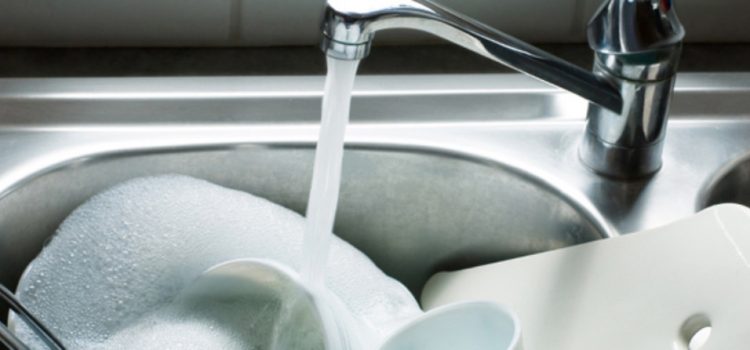 A sink fills with water to wash dishes.