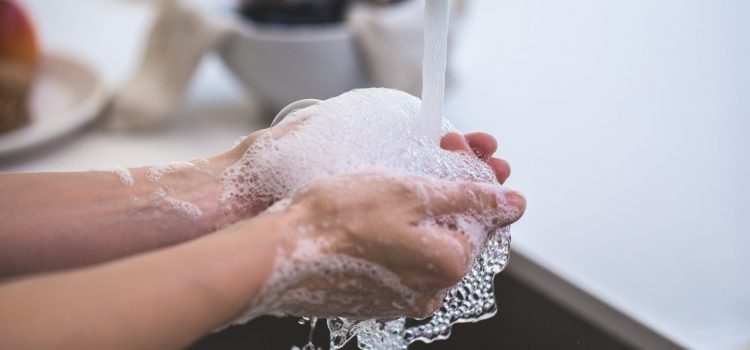 person washing their hands in the sink