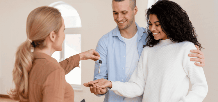 A realtor hands over the keys to a couple in Houston. Make sure to ask questions about the home's water quality while looking for a new home.