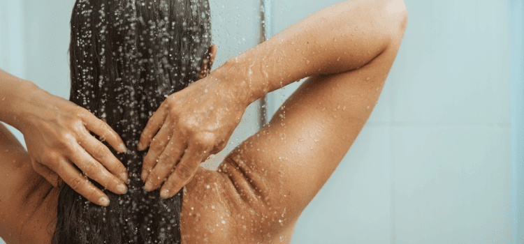 An image that depicts a woman showering. You can save money on water bills by simply shortening your shower by a few minutes. More money saving tips are available here on this blog.