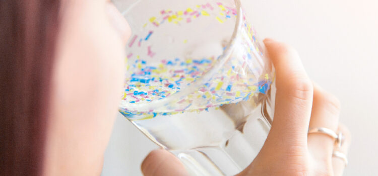 An individual preparing to drink water displaying visible microparticles resembling bacteria found in untreated Houston tap water prior to Houston water filtration and softener installation.