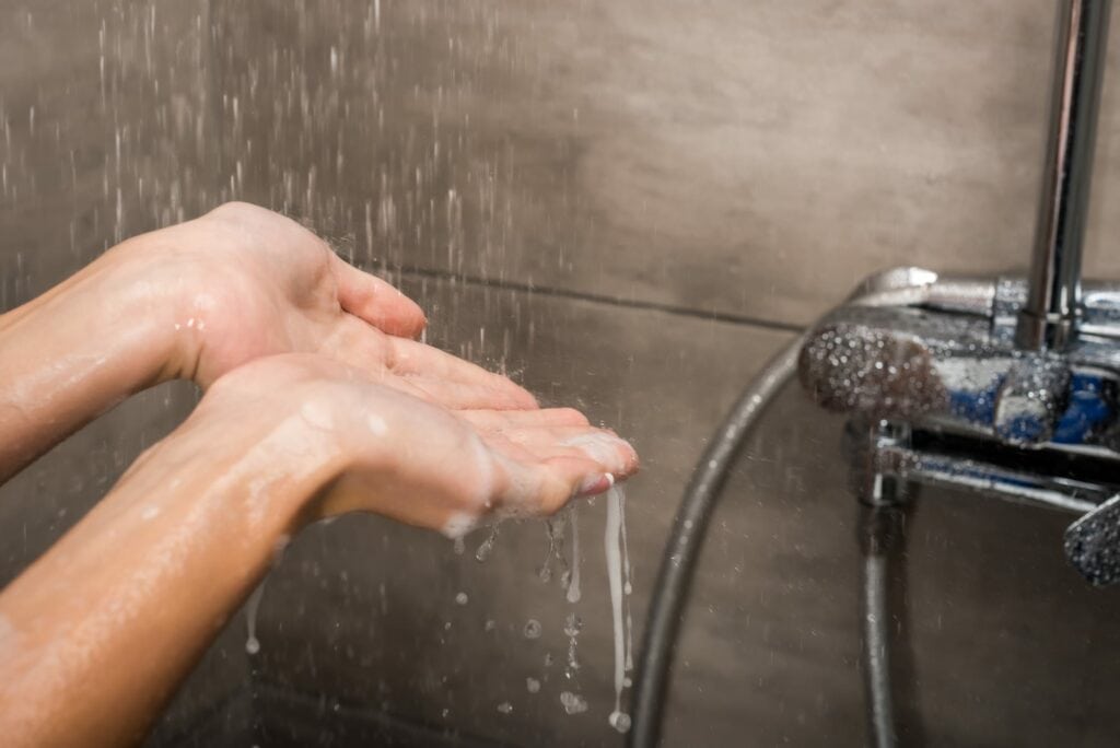 Water flowing through hands in the shower