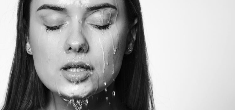 An image of a woman rejuvenating with the help of water cascading down her face, promoting relaxation and clarity. Houston TX water conditioners enhance the overall water quality for a refreshing experience.