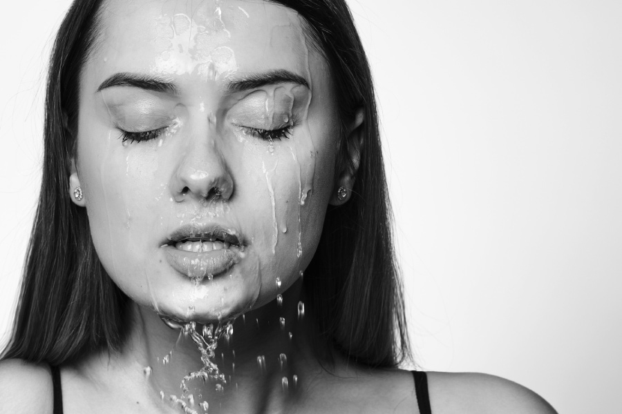 An image of a woman rejuvenating with the help of water cascading down her face, promoting relaxation and clarity. Houston TX water conditioners enhance the overall water quality for a refreshing experience.