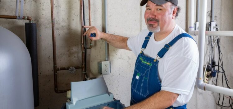 A technician servicing Houston water softeners in a utility room.