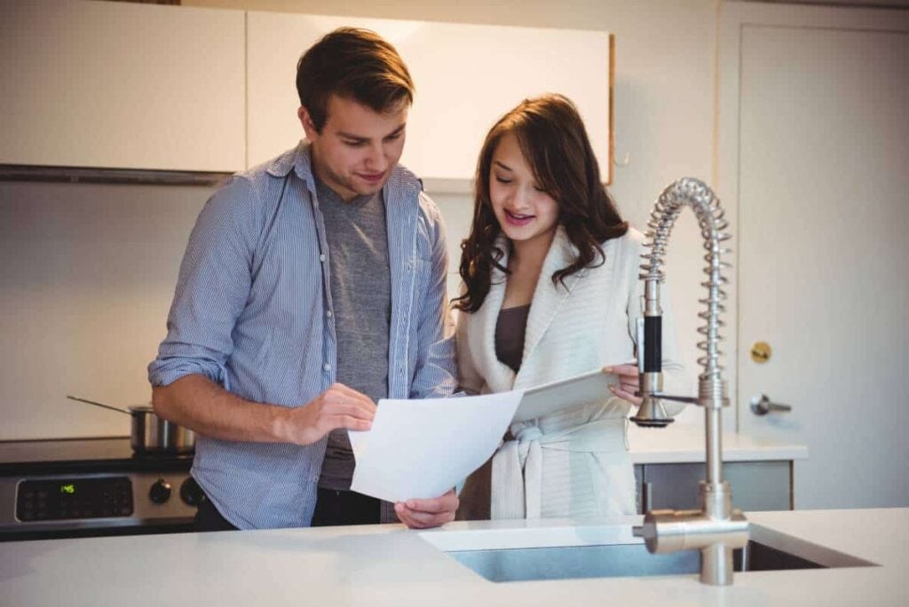 A couple discussing Pasadena water softeners and water treatment options in their kitchen.
