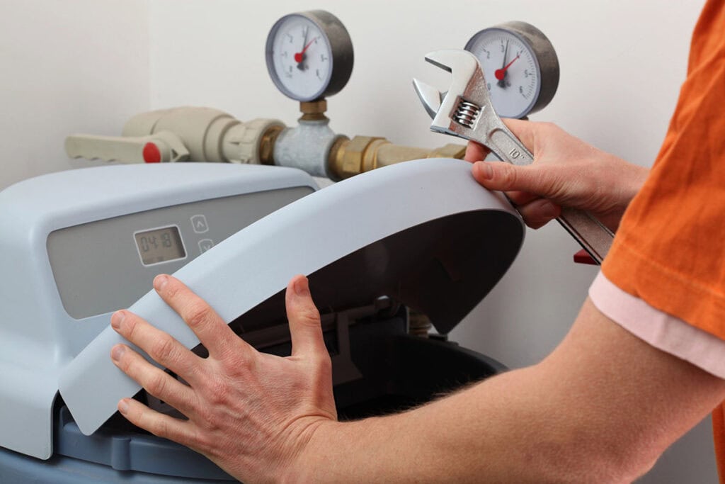 A technician from one of the leading water softener companies in The Woodlands performing maintenance.